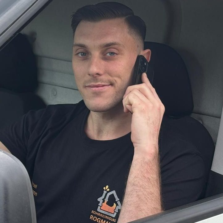 Rohrreiniger am Telefon im Firmen Auto Der Rohrreiniger telefoniert mit einem neuen Kunden.